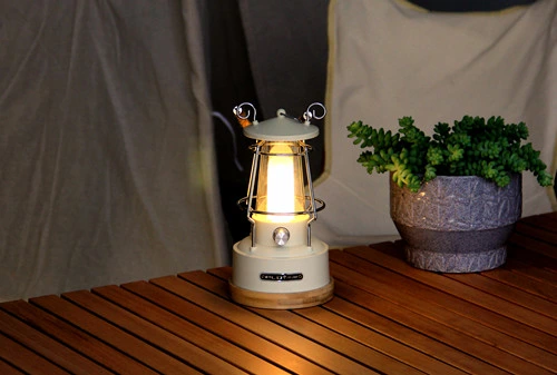 Lampe de camping vintage à LED rechargeable avec batterie et bandoulière.