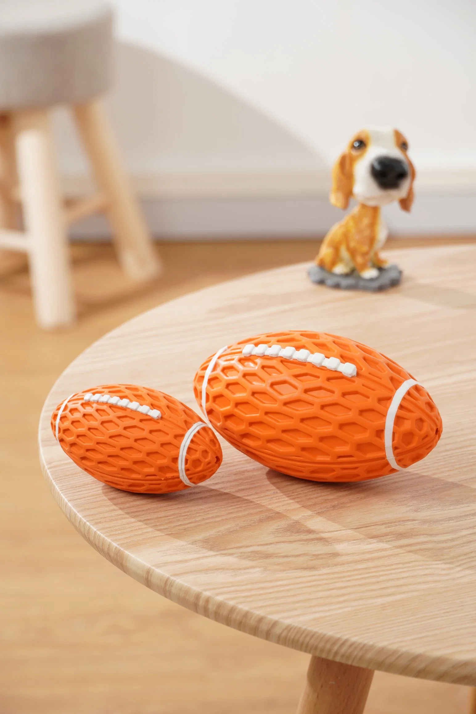 Juguete de perro de goma con forma de balón de rugby que hace ruido al apretarlo