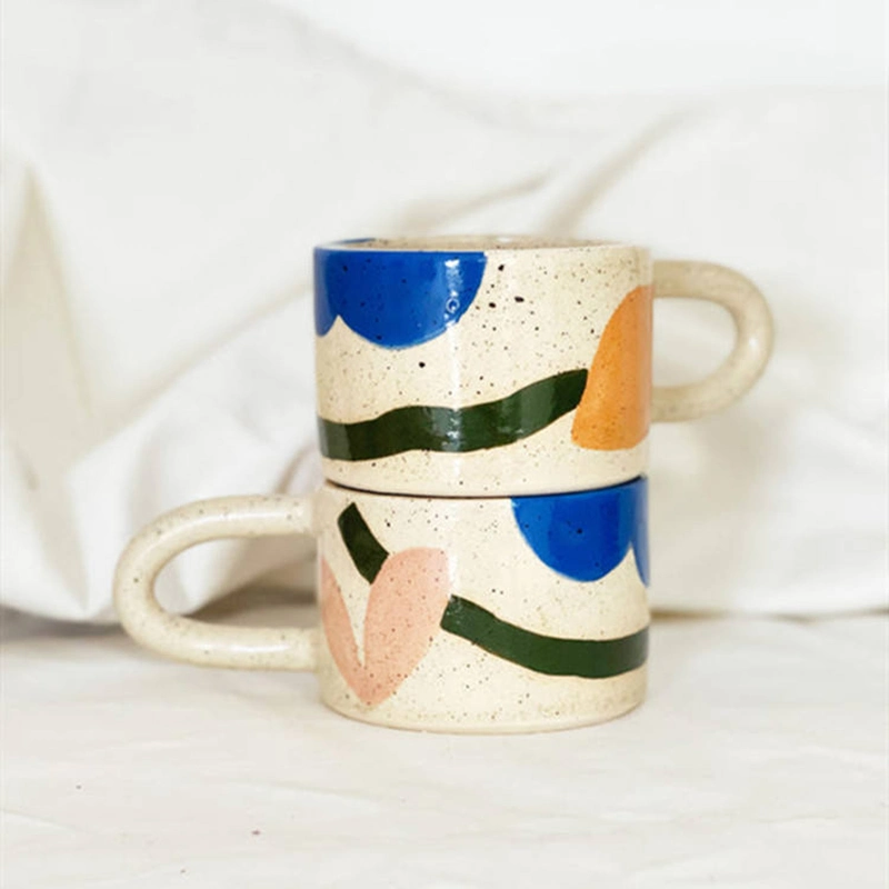 Caneca de café ou chá com alça gordinha e estilosa, com estampa pontilhada colorida de bolinhas, seguindo a tendência estética contemporânea nórdica.