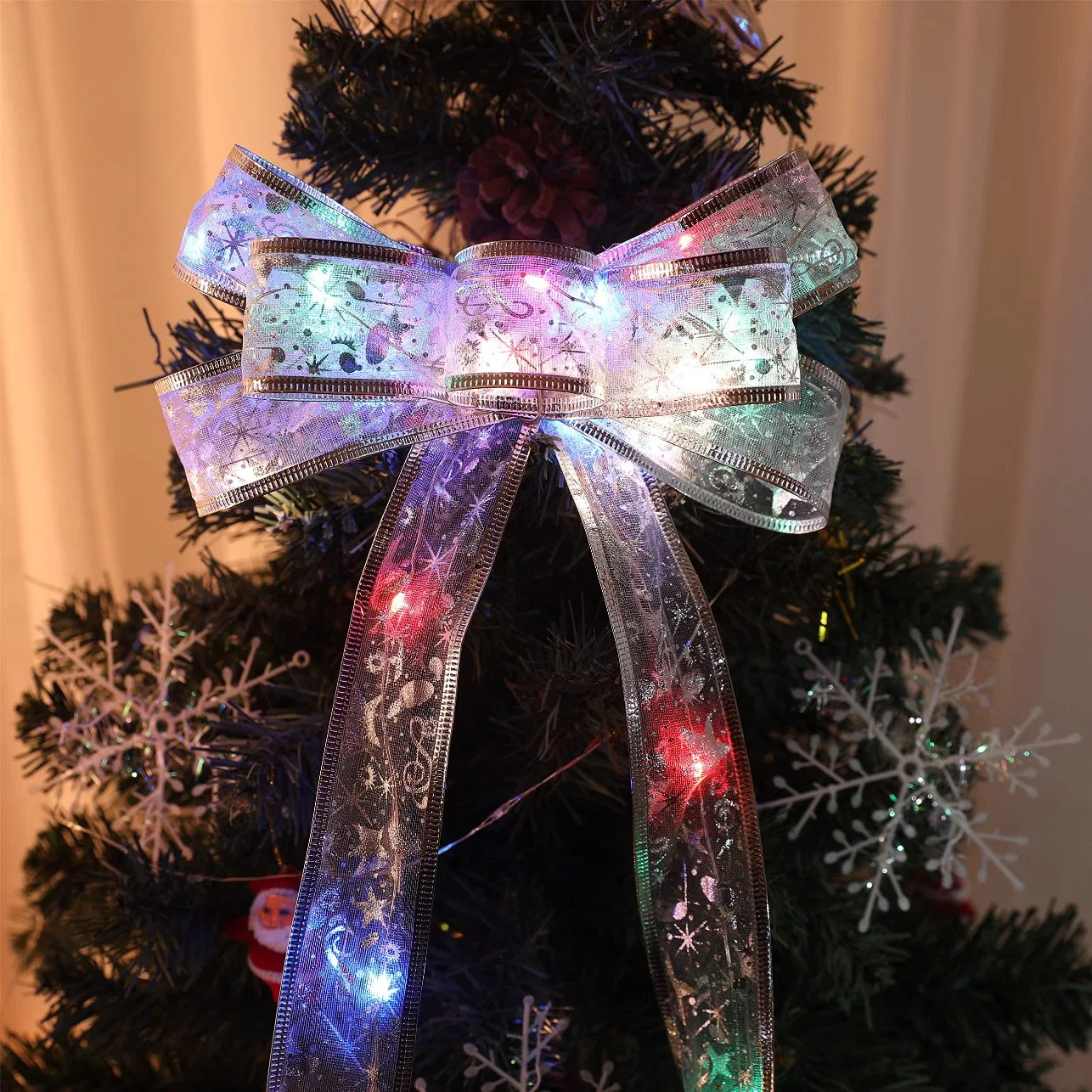 Guirlandes lumineuses en ruban LED en fil de cuivre pour sapin de Noël avec des nœuds féeriques.