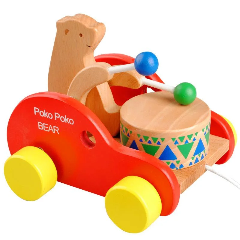 Деревянный медведь бьющий барабан тянет вдоль игрушечного автомобиля детской игрушки