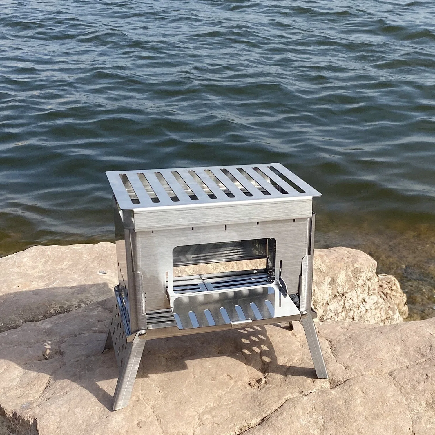 Petit barbecue pliable et léger en forme de carré avec grille au charbon de bois.