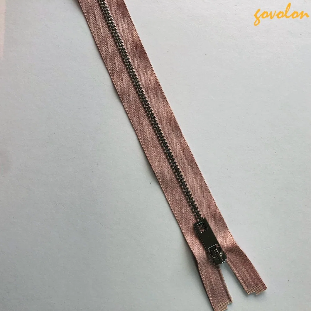 Tirette rose pour vêtements avec fermeture éclair de 52 cm à dents métalliques argentées.