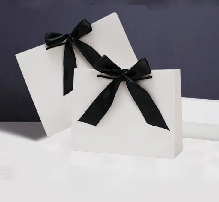 Bolsa de regalo de ropa de la tienda de suministro de topos y lazo personalizado Joyería Bolsa de regalo Compras Bolsa de papel Fabricantes a medida Ventas directas Logotipo personalizado