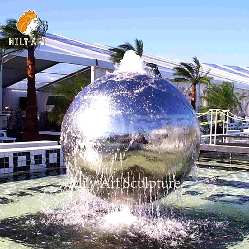 Piscine extérieure avec statue en acier inoxydable et fontaine d'eau en forme de boule.