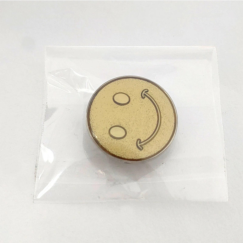 In French, the translation of "Gold Plated Sanded Metal Craft Souvenir Smiley Face Pin Badge" is "Insigne de broche en métal sablé plaqué or, souvenir d'artisanat avec un visage souriant".