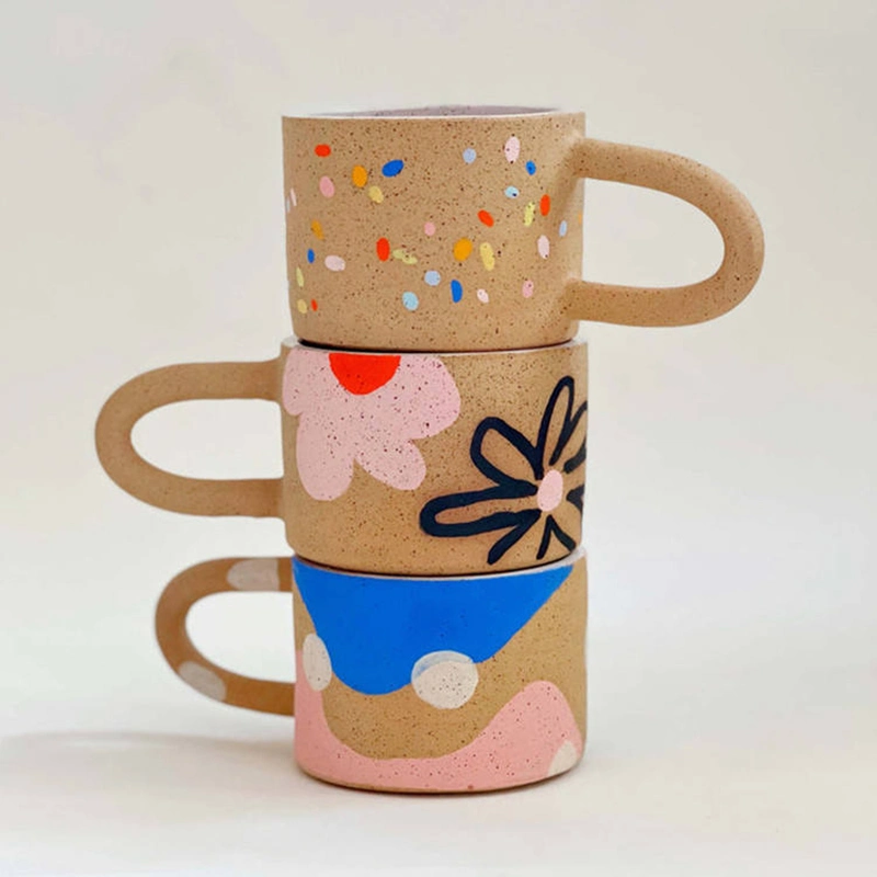 Caneca de café ou chá com alça gordinha e estilosa, com estampa pontilhada colorida de bolinhas, seguindo a tendência estética contemporânea nórdica.