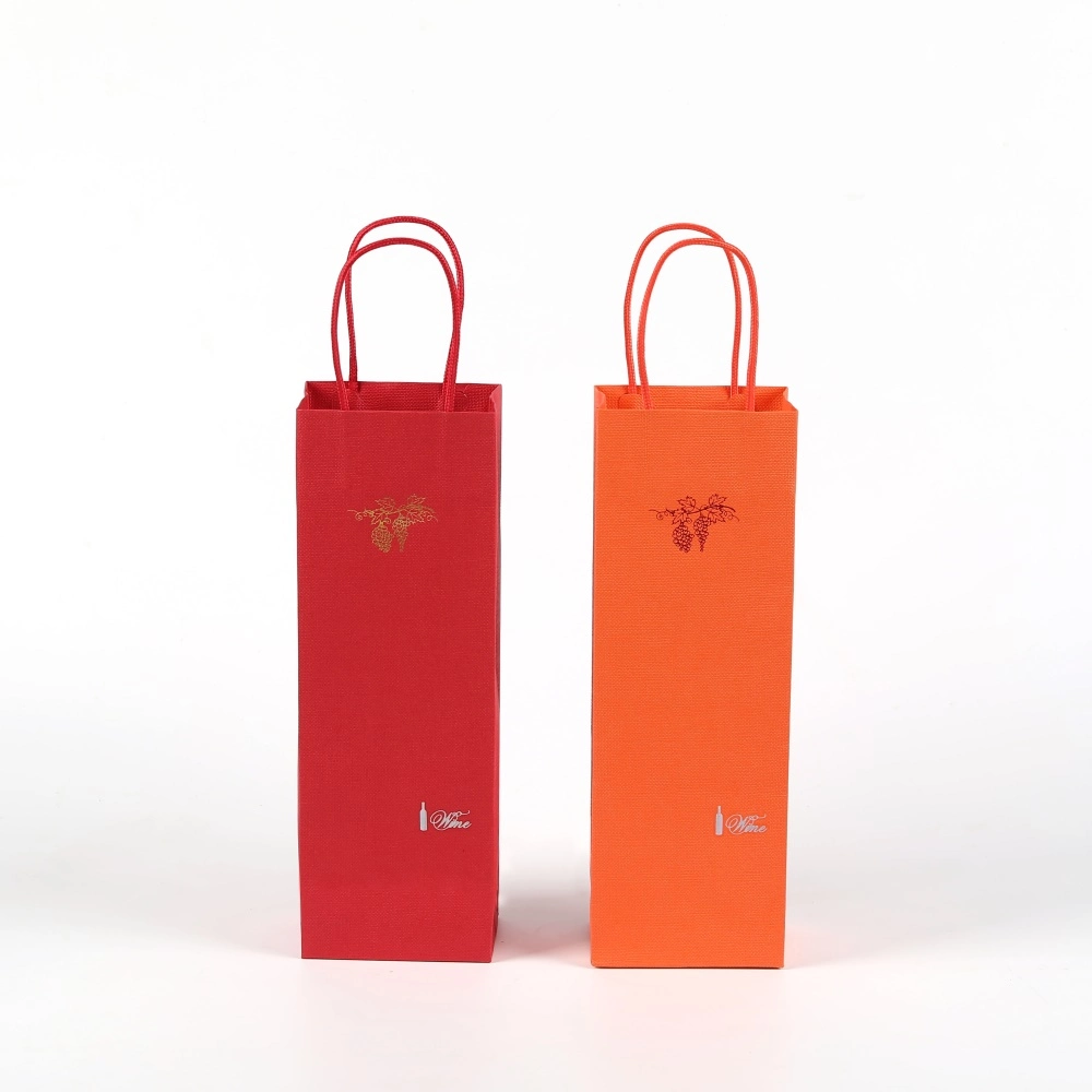 Sacs cadeaux en papier argenté et rouge pour bouteilles de vin avec estampage à chaud.