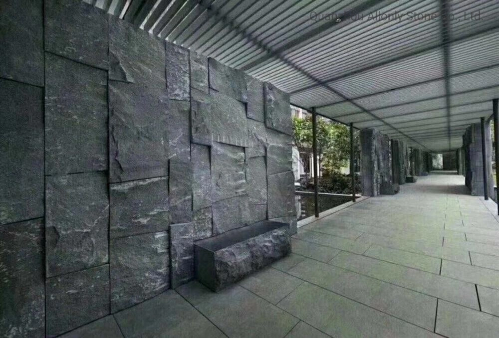 Diseño de jardín exterior con baldosas de piedra natural. Revestimiento de pared de granito negro en forma de seta.