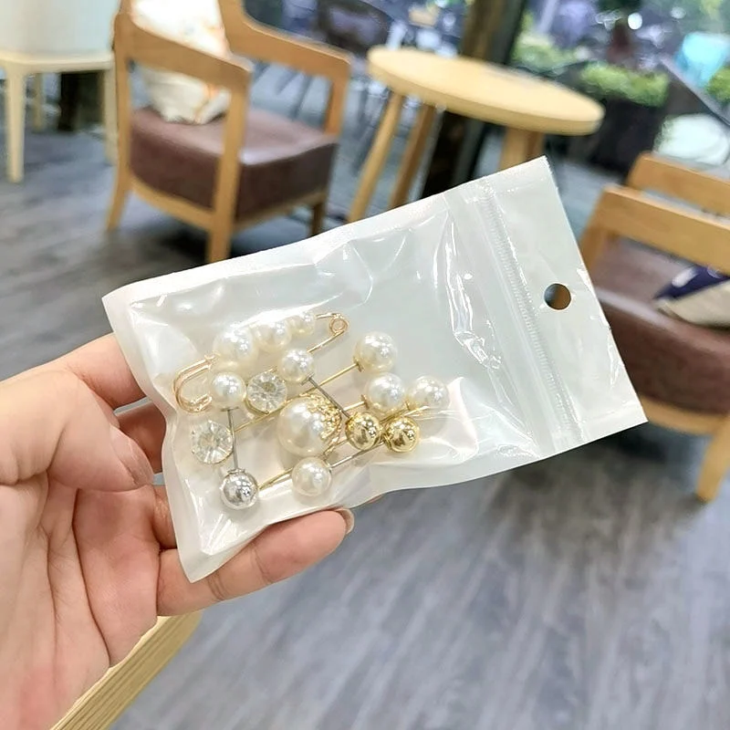 2023 Delicous Anti-Aliasing Pearl Broche Broche Femenino de una línea pasador Cross-Border Accesorios de ropa de pin Falda con botones de bufanda