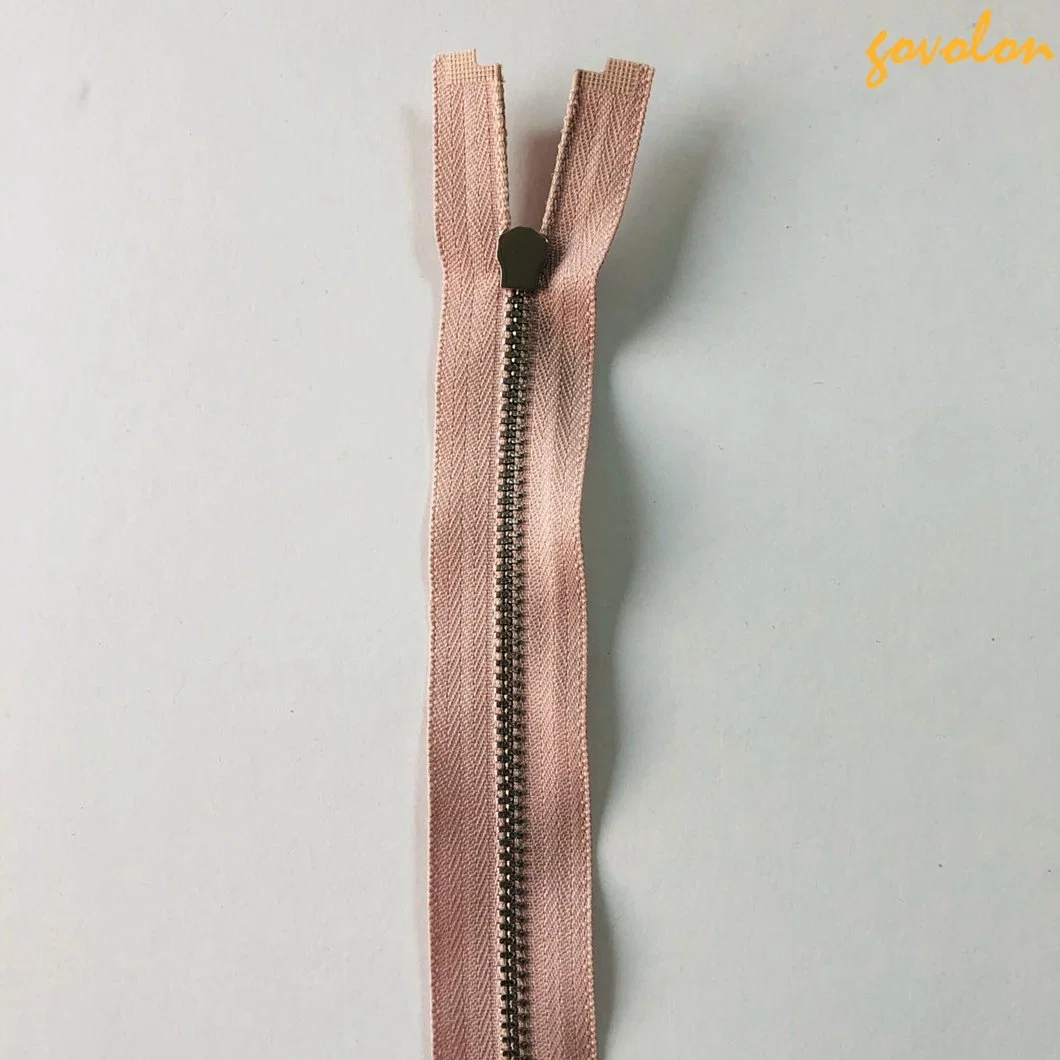 Tirette rose pour vêtements avec fermeture éclair de 52 cm à dents métalliques argentées.